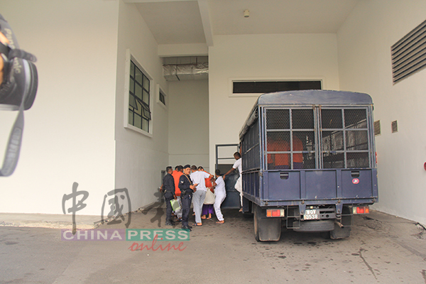 被告山吉古马（右起）、雷蒙拉基及比林西加，在警方严加监护下，步下警车走进法庭。