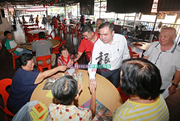 芭蕾新村村长竞选期，陆兆福（站者右2）率领候选人张洪铭（右3）于新村茶餐室沿桌与拜访村民，寻求委托。