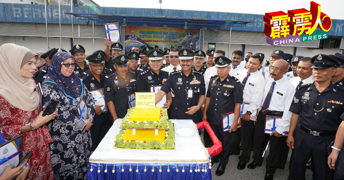 拉扎鲁丁（前排左6）率领获得2018年警队杰出服务奖的警察，共切马来传统黄色糯米糕。