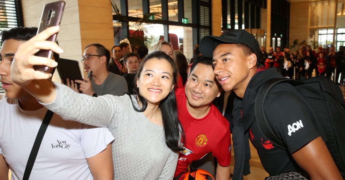 曼联抵达新加坡时受到热烈欢迎，球迷捉紧机会与林加德（右）合照。（曼联球会推特）