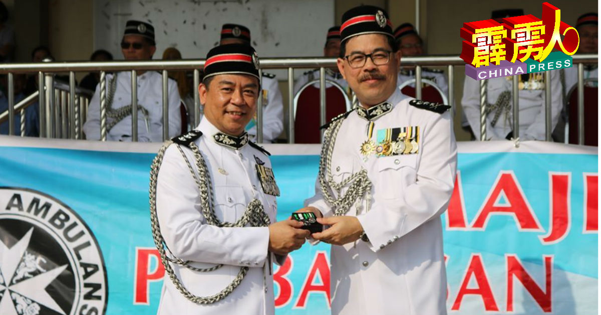 陈东铭（右）颁发111周年纪念勋章给刘咏钢（左）。