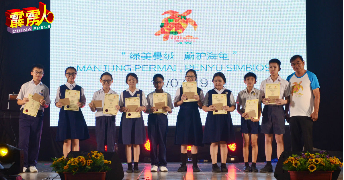 郭进光（右）颁发奖金和奖状给散文比赛小学组的优胜者。