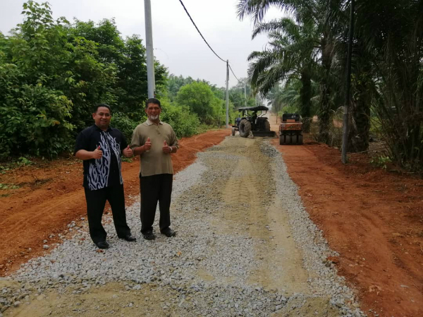 马六甲宾达甘榜德苏顺通往南北大道爱极乐休息站的路段获得提升。左起峇哈鲁丁与阿利亚纳央。