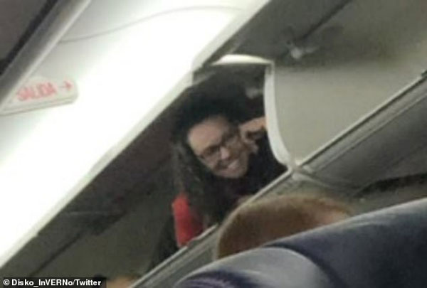 西南航空一班机的空姐爬上座位上方的行李柜。（推特）