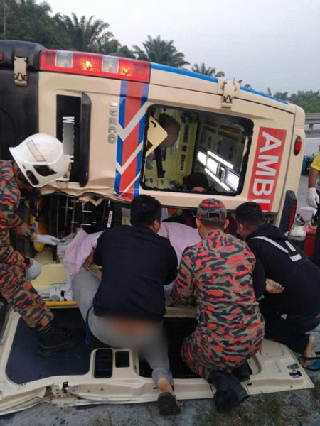 消拯员从救护车的后门救出伤者。