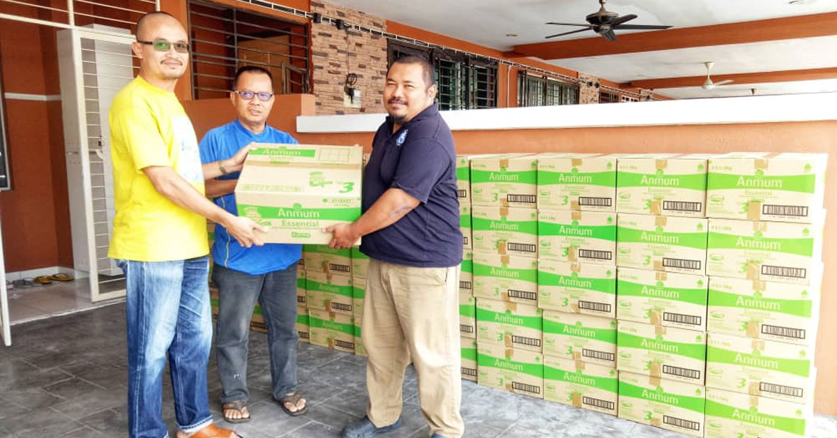 阿兹敏依萨（左）把奶粉，移交给马来西亚半岛新闻从业员职工会《马来西亚前锋报》分会秘书莫哈末峇西（右）。
