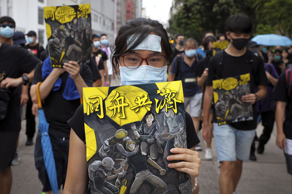 参与游行的示威者手持海报，赞扬反送中人士“同舟共济”。