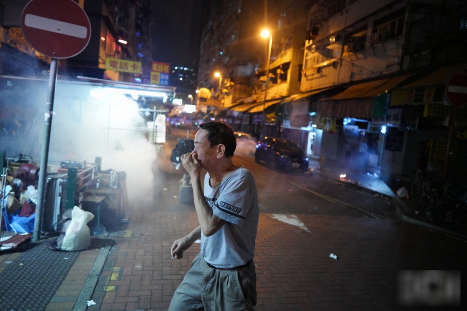 警方在无示威者的街道发射催泪弹，当地居民须掩面而过。