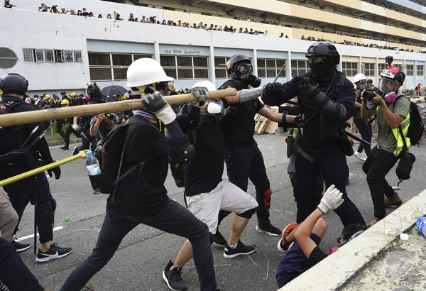 黑衣人拿竹棍打防暴警察。