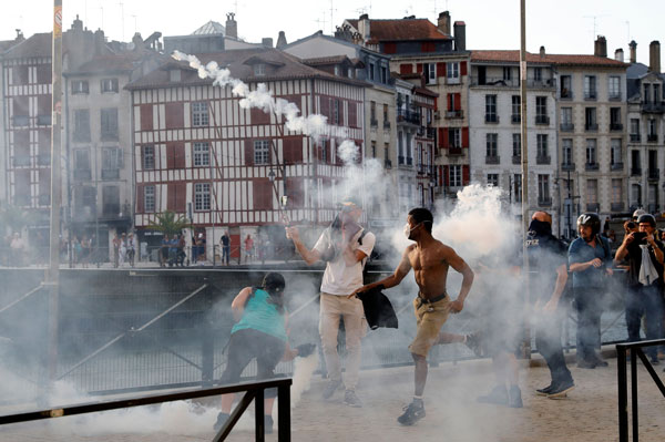 在法国西南部城市巴约讷，示威者向警方回击榴散弹筒。（法新社）