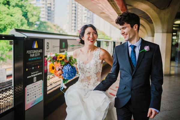 新人在地铁车厢内拍结婚照，引来众人好奇的目光。 