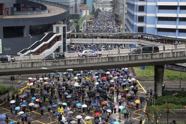 示威者撑伞参与周日的荃葵青游行。