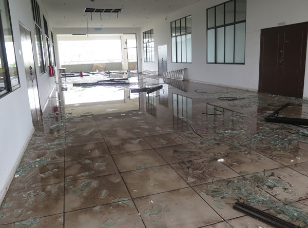 四楼文物馆和宿舍走廊玻璃门倒下，现场满地玻璃碎片和积水。