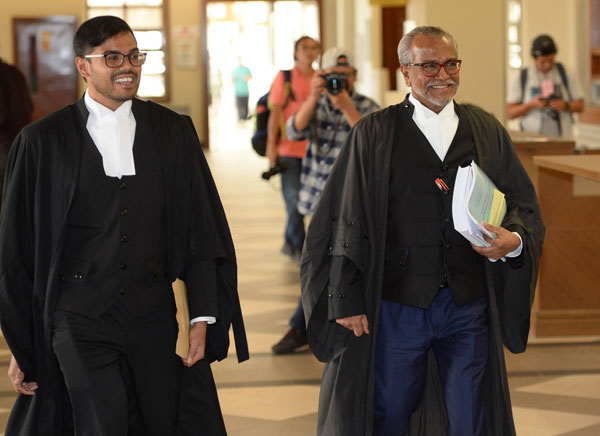 沙菲宜（右）与儿子莫哈末法汉一脸笑容，步入法庭。