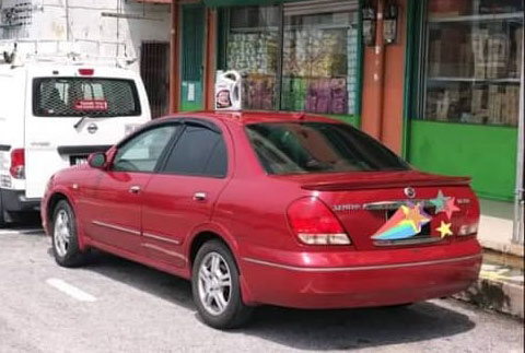轿车顶上置放代表“卖车”的空机油瓶，被执法人员开出罚单。