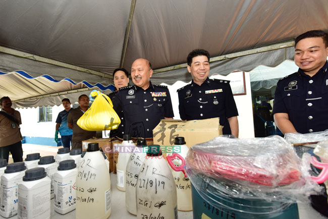莫哈末卡马鲁丁（前排左2）展示警方起获的炼毒药水；前排左为陈毅豪、前排右为李庆泉。