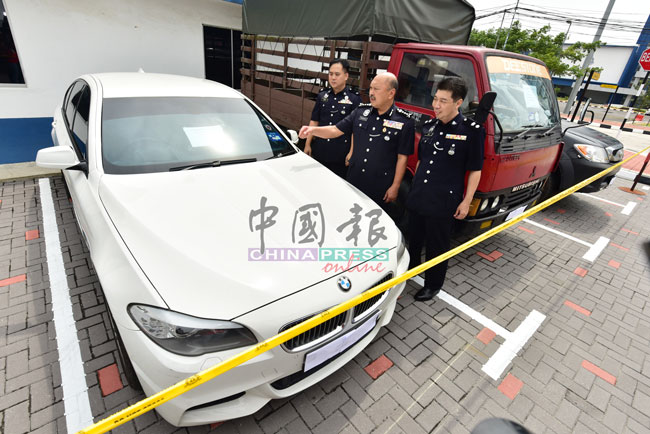 陈毅豪（左起）、莫哈末卡马鲁丁及李庆泉，检查警方所充公的其中一辆宝马轿车及罗厘。