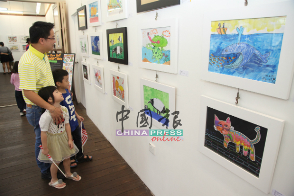 家长与孩子一同赏画，支持慈善画展。