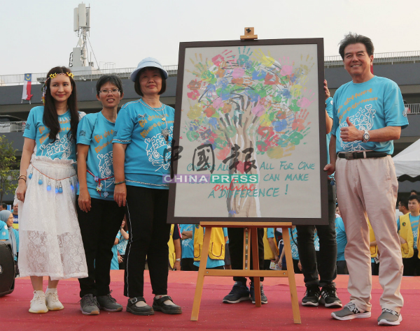 史进福（右）回赠2013年标下的画作给马六甲肯纳儿协会，由王湘莹（左起）、姚美芹及黄玉环代表接领。