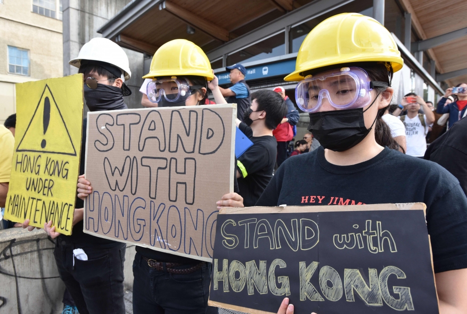 香港支持者身穿黑衣，手持字牌标语“挺港”在温哥华抗议。