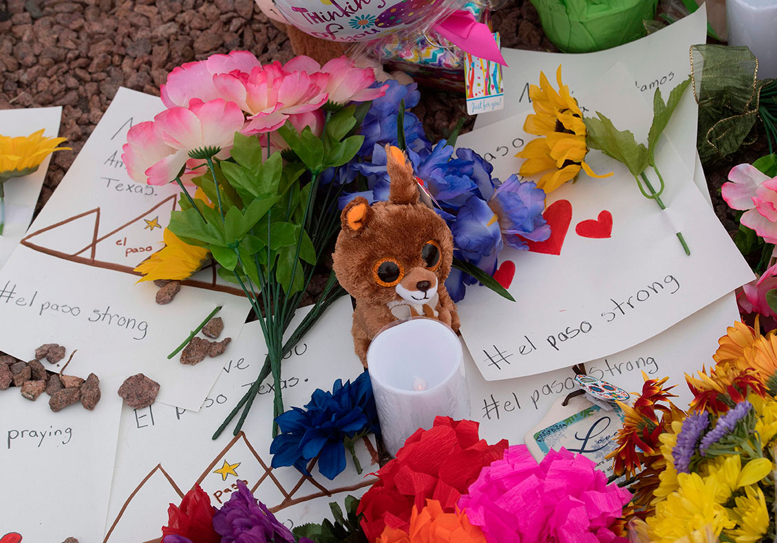 有民众周日在德州沃尔玛超市外置放鲜花、吊唁信和绒毛玩偶，哀悼枪击案死者。（法新社）