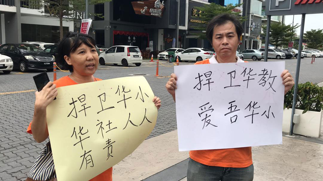 针对华裔夫妇提前来到酒店前，穿上希盟“ubah”衣服，举起大字报反对爪夷书法进入华小。