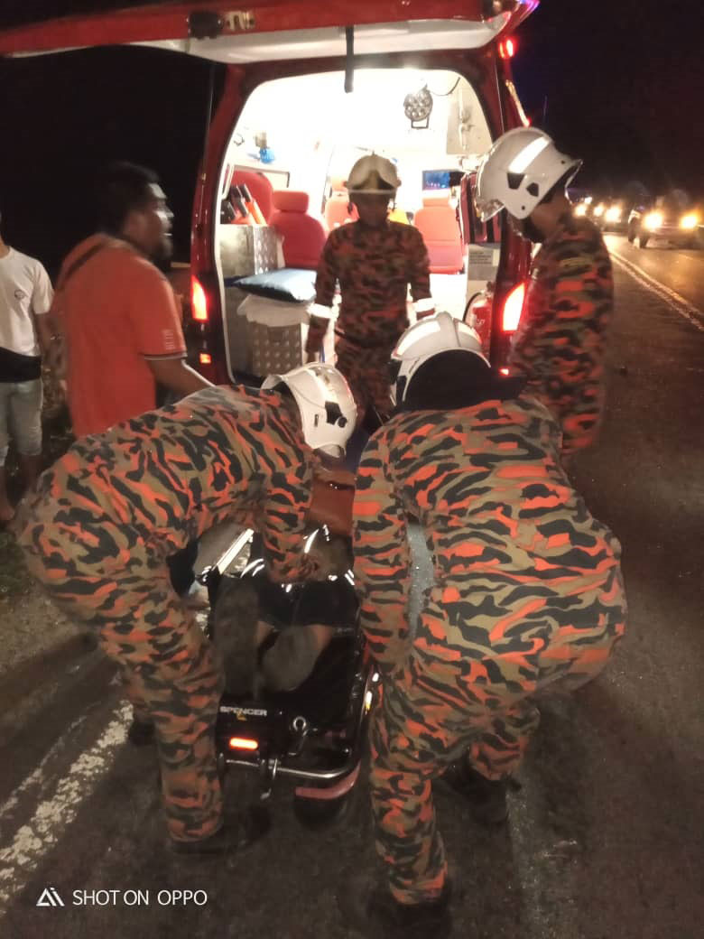 消拯员将车祸伤者救出车外，并送往医院治疗。