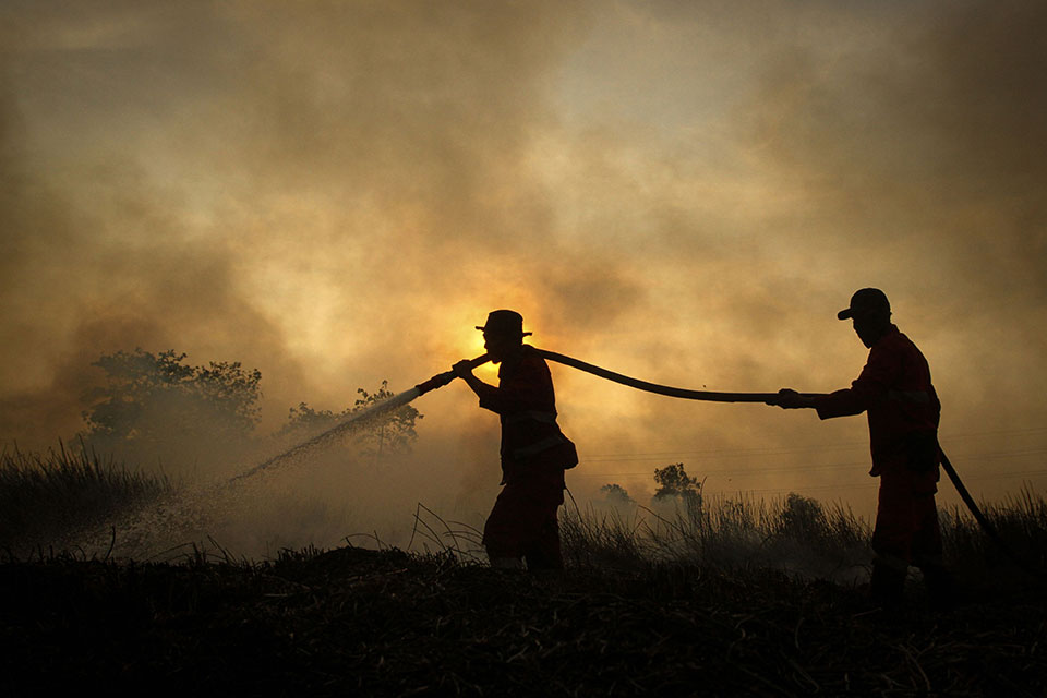 消防员在南苏门答腊的奥干伊利尔区，洒水扑灭一处泥炭地森林的野火。（法新社）