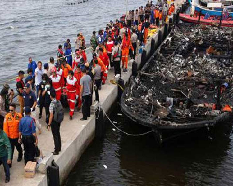 搜救人员救起61人，一旁的渡轮被烧的焦黑。
