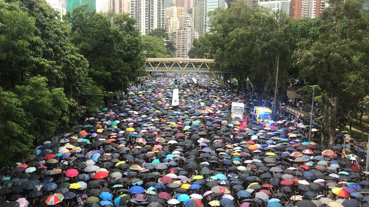 “818集会”下起大雨，不少游行人士遂举起雨伞。