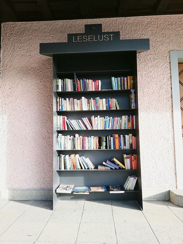 湖边公园中间的亭子，摆放了装满书的书架，供游客阅读。