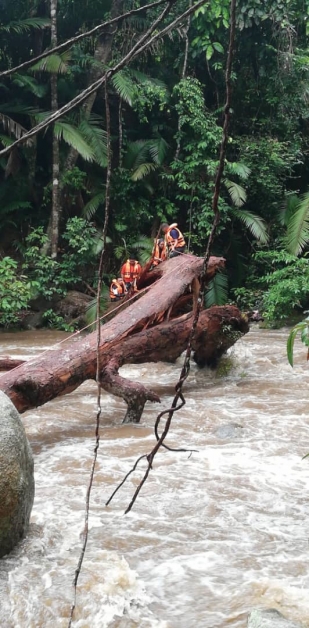 在拯救人员的协助下，一对受困洪水的年轻马来男女，最终安全脱困。