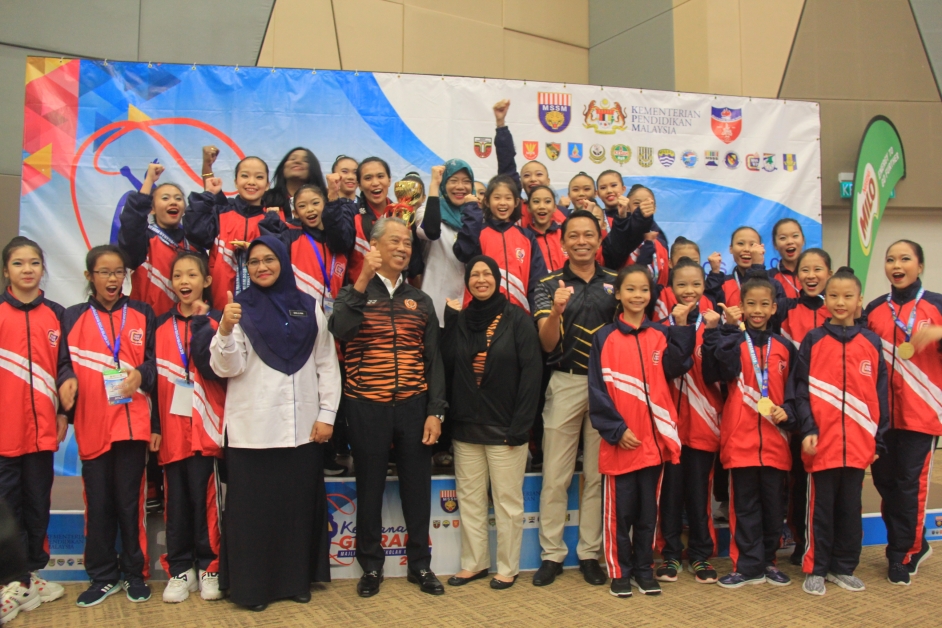 慕尤丁（前左5起）偕同夫人，与获得全马韵律操总冠军的吉隆坡队健儿们和老师。