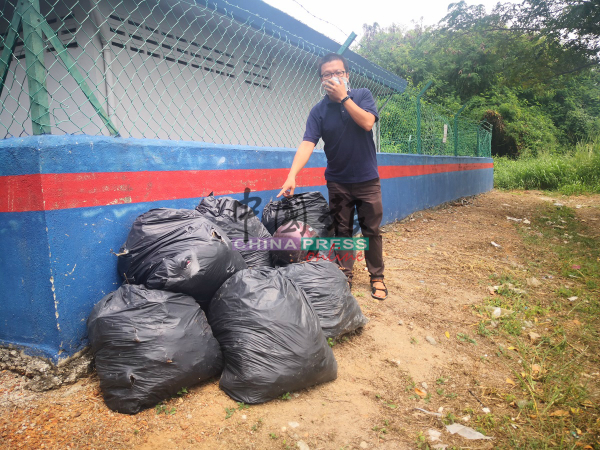 李春源展示承包商在清沟后，将一袋袋的垃圾丢在一旁。