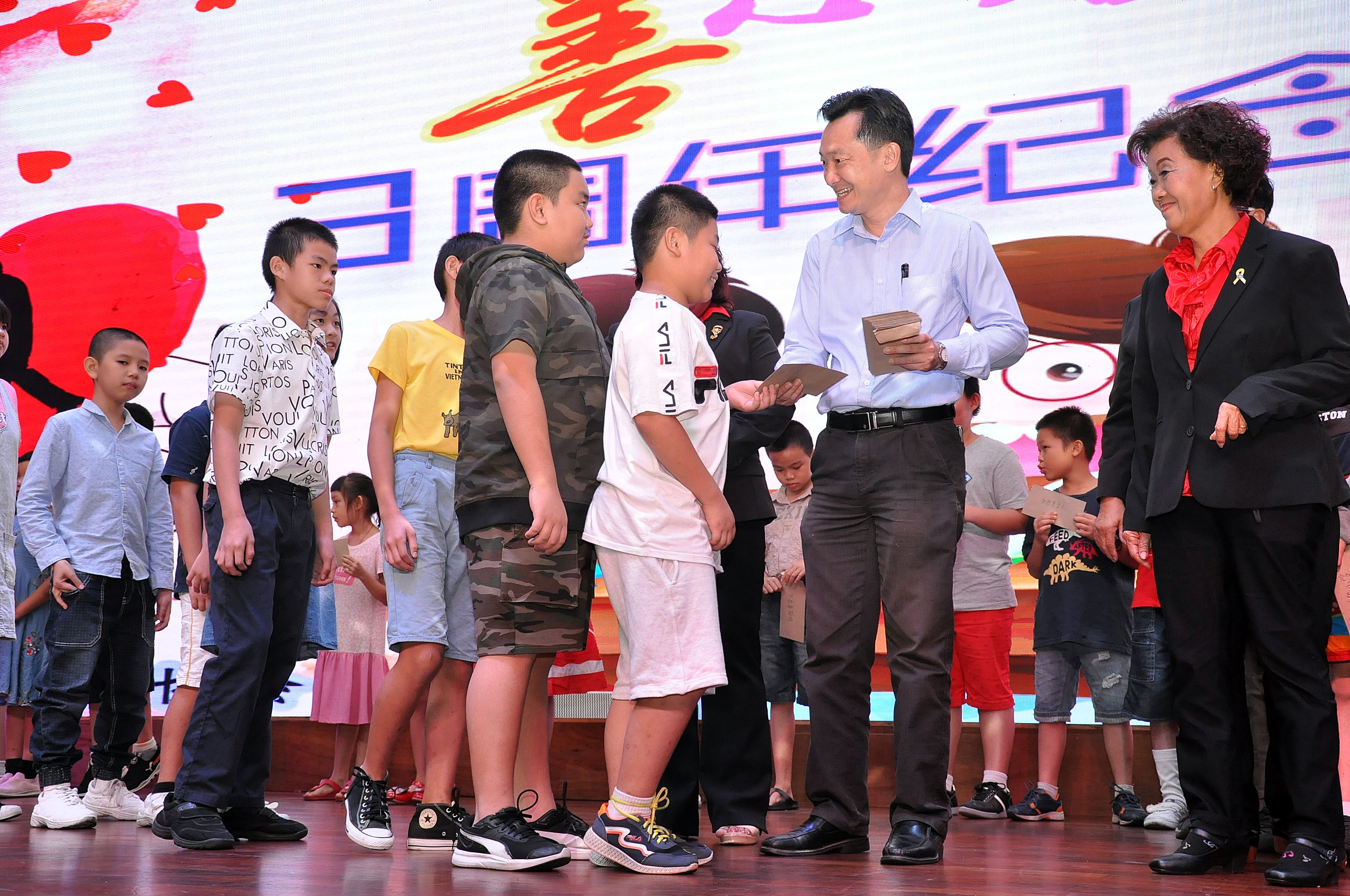 谢琪清（右2）移交助学金予受惠小学生，右为林美伶。