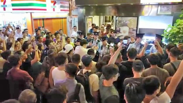 浸大生疑因购买雷射笔被警员拘捕，大批街坊不满起哄。