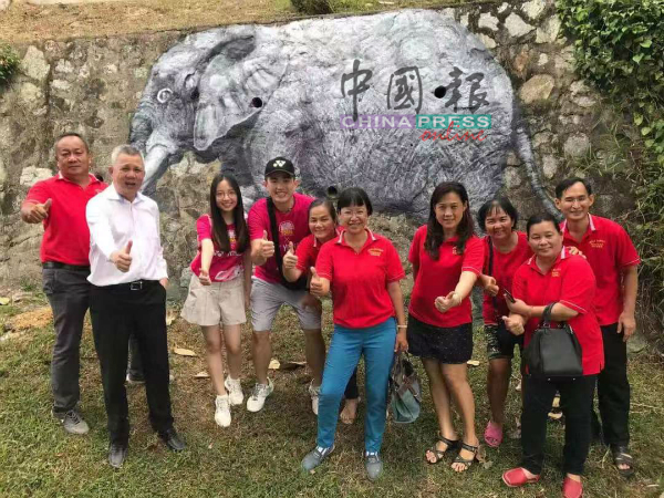 台湾游客从面子书看万茂新村的街画，到新村四处“打卡”，受到州议员叶耀荣（左2）及村委的欢迎。