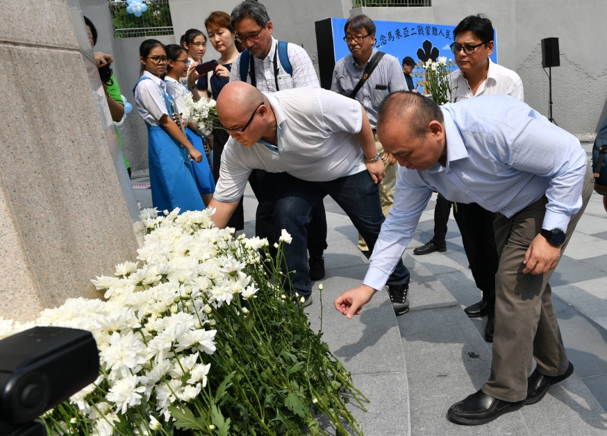 学生及民众到马来亚二战人民蒙难纪念碑献花，纪念在二战牺牲的勇士。