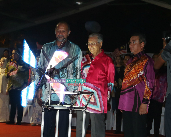 马哈迪（左2）在哥宾星（左）及阿德里陪同下，为2019年国庆月及辉煌条纹推介礼主持开幕仪式。