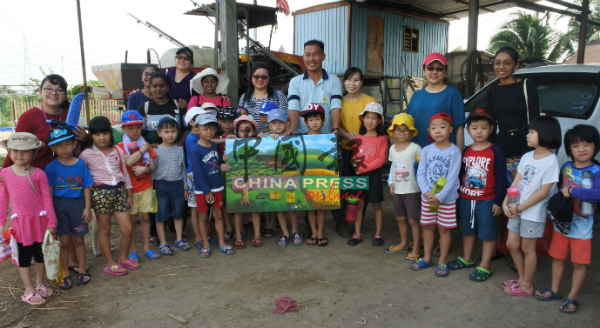 与田园小屋拥有同理念的幼教中心，带着6岁的学生到稻田参与插秧与收割时，赠画给黄瑞杰夫妇（后排右3起）。