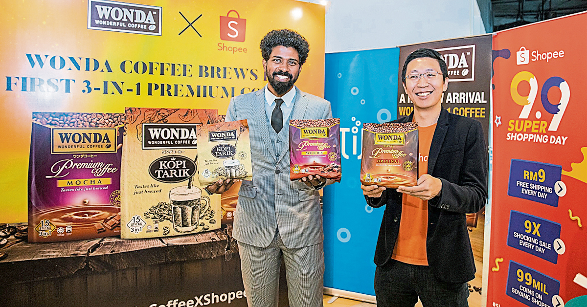 山达鲁班（左）与大马虾皮分类经理陈明杰（译音）一起推介备有3种口味的WONDA三合一优质咖啡。