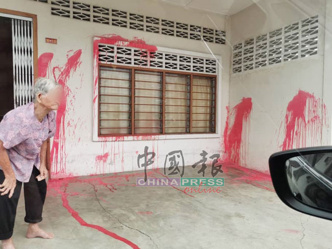 蔡美莲无奈看着住家遭人泼漆，门前及地面皆沾满红漆。
