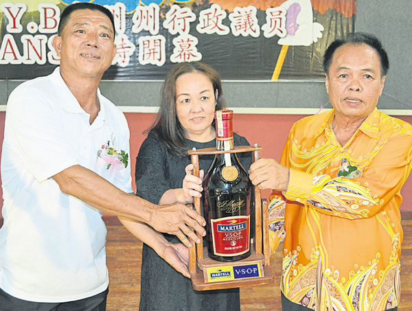 李亚玖（右）与郑登禹（左）移交3公升装的妈爹美酒给得标的G One公司代表，标价3444令吉。