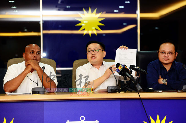 吴健南（中）展示Grab管理层的回函，左起为该运动成员莫哈末拉兹夫和辜国顺。