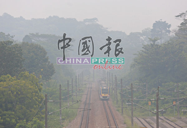 一列火车穿梭在雾霾中，镜头拍摄只能看到前半段的车厢。