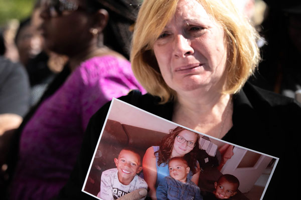 约翰娜母亲周三在勒阿佛尔市政厅前参与集会，她手持女儿和三个孙子的合照，伤心流泪。