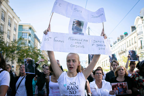 一名女子举起布条，抗议妇女被伴侣杀害，要求公义。