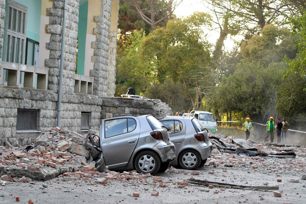 地震发生后，掉落的瓦砾砸坏多辆汽车。（法新社）