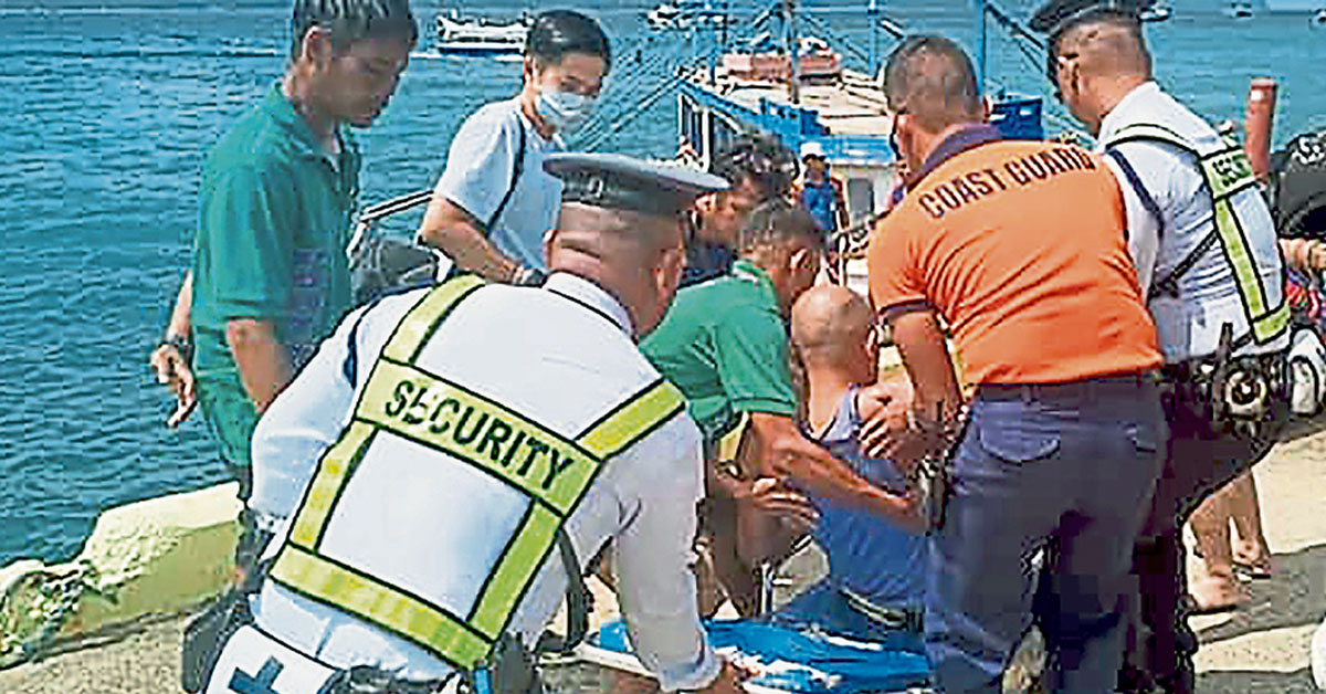 多名海岸警卫队人员把一名获救男子送上救护船。（美联社）