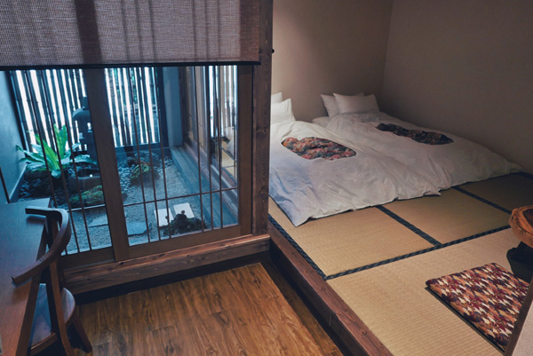 房间内除了榻榻米和日式铺床，还有一个室内庭园造景。